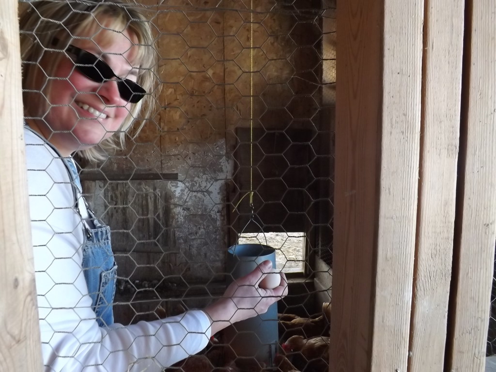 Fannie holding an egg in the chicken coup