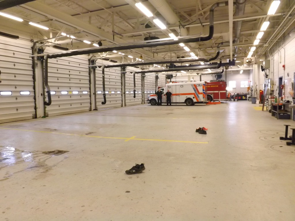 Rushworth (left) and Bowen (right) stand in front of the 'emergency' ambulance in the empty bay. All paramedic crews are off base and out on calls. 